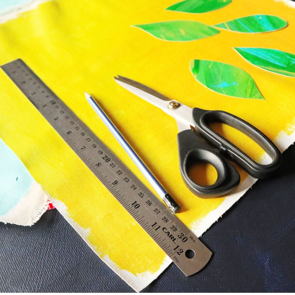 picnic season really big picnic rug yellow painted canvas with green cut out leaves, ruler and scissors